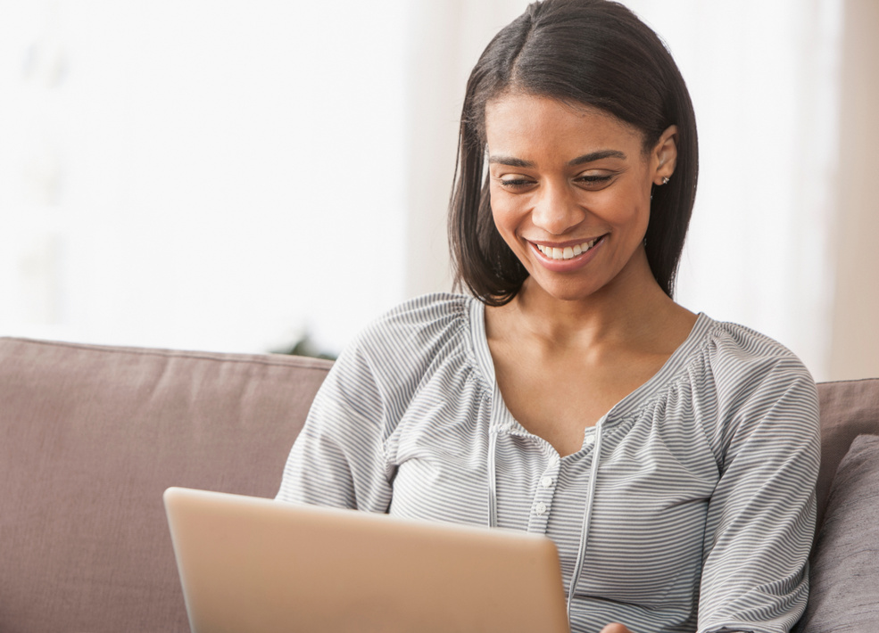 Young woman smiling while looking at laptop