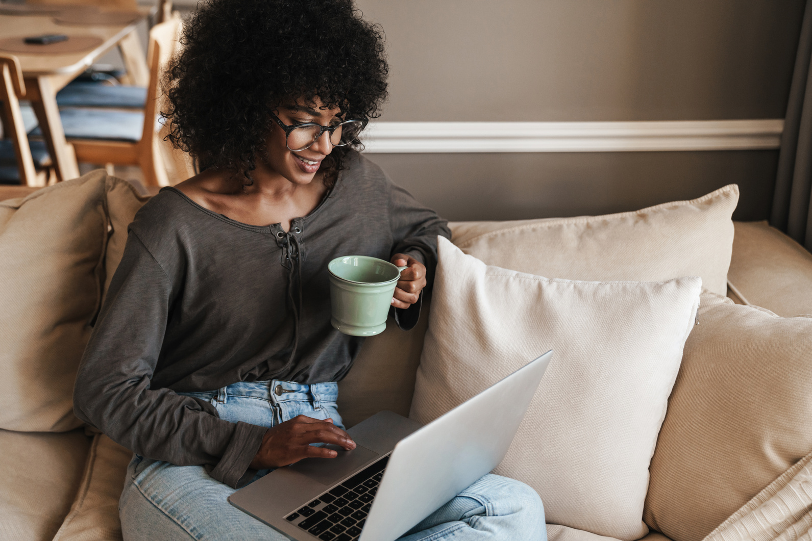 Image of African American Woman Working with Laptop While Drinking Coffee