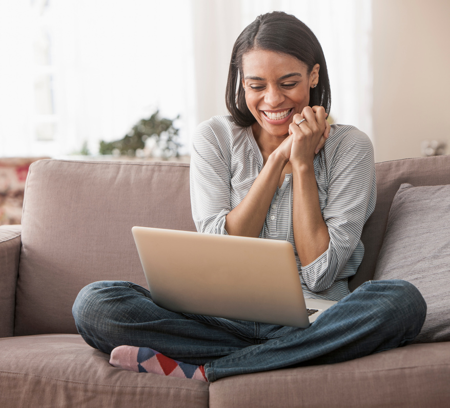 Young woman excited while looking at laptop